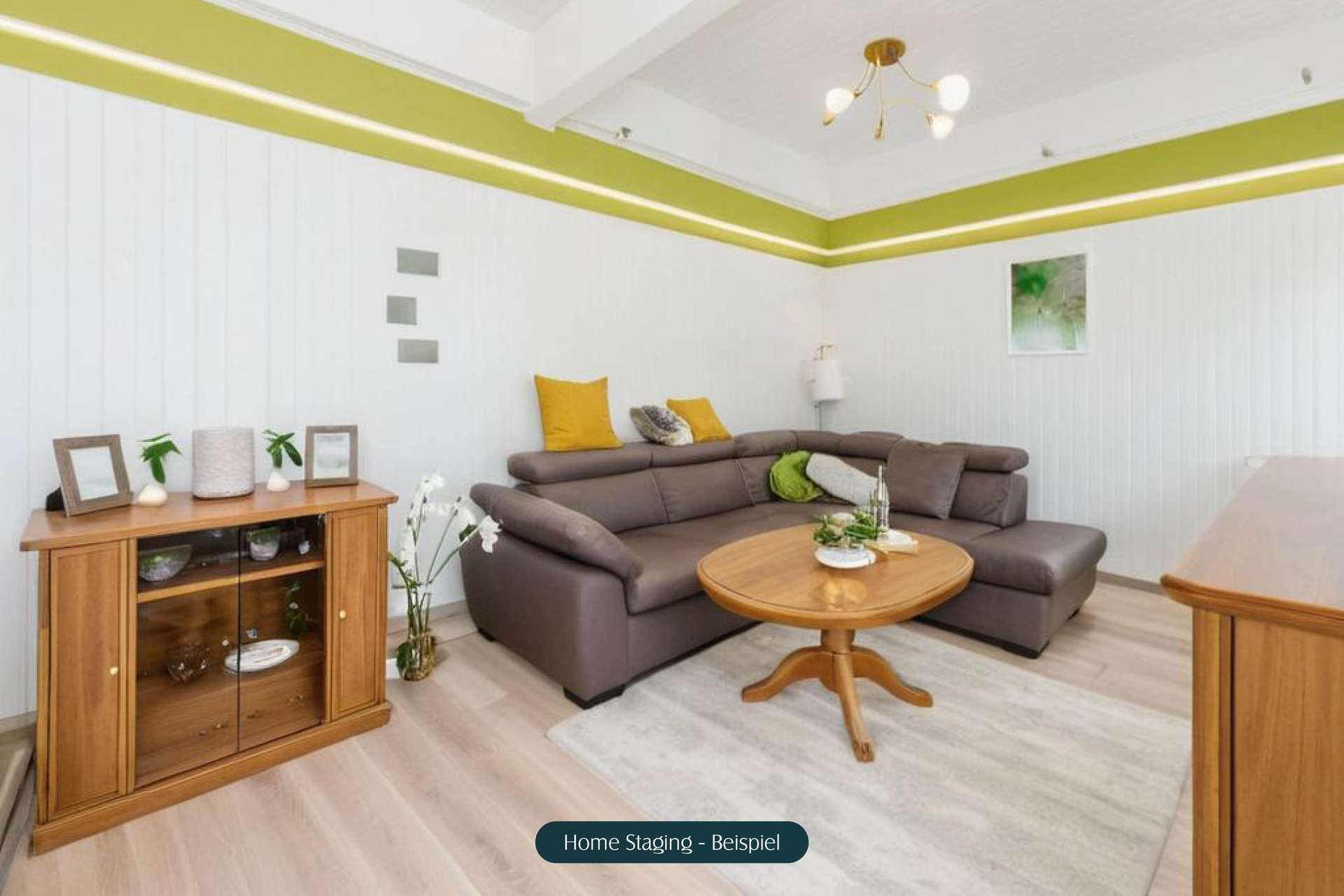 Modernes Wohnzimmer mit einer braunen Couch, einem runden Tisch und dekorativen Kissen, hellen Wänden und Pflanzen.