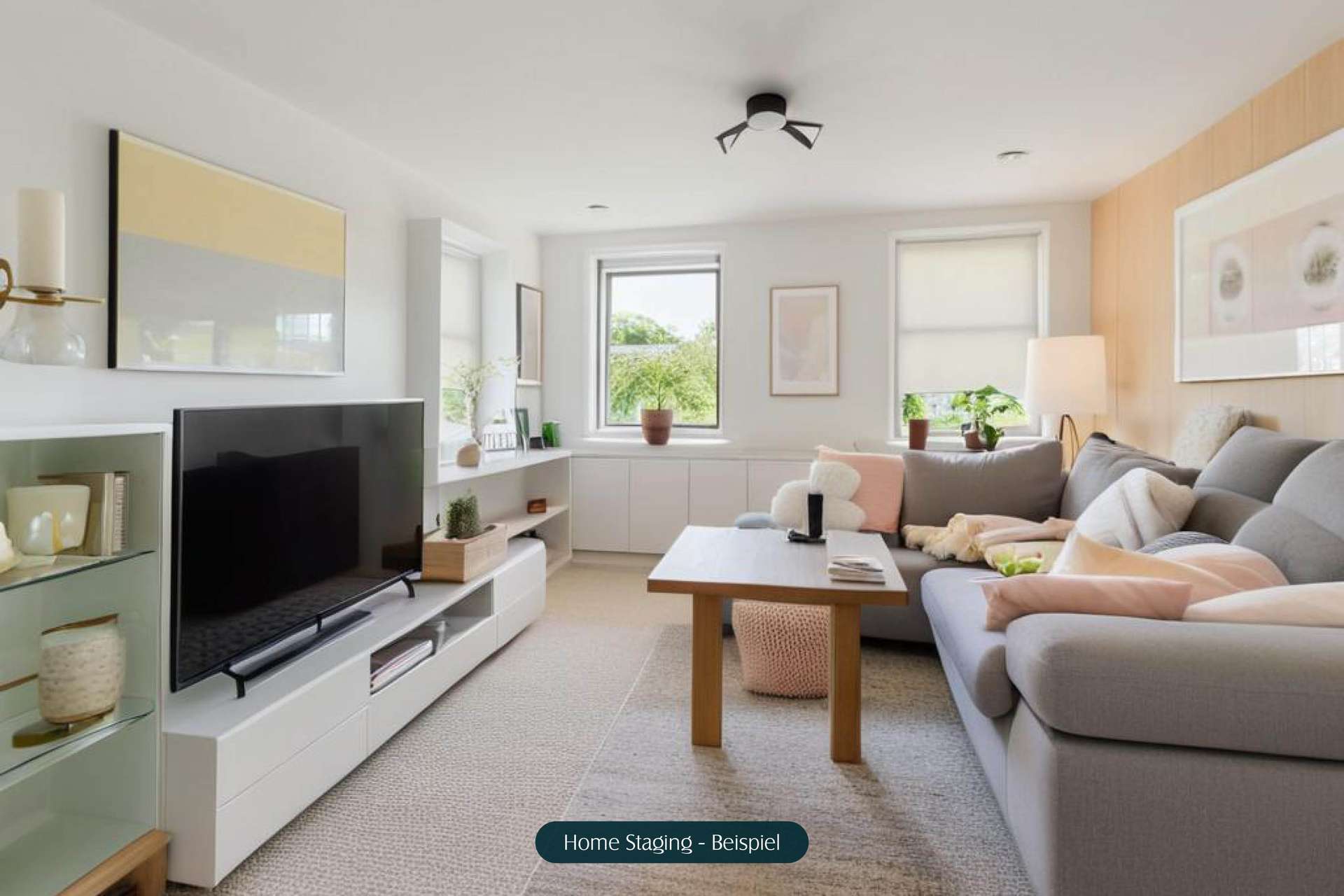 Modernes Wohnzimmer mit grauem Sofa, Holztisch, TV und hellem Dekor. Helle Fenster mit Blick ins Grüne.
