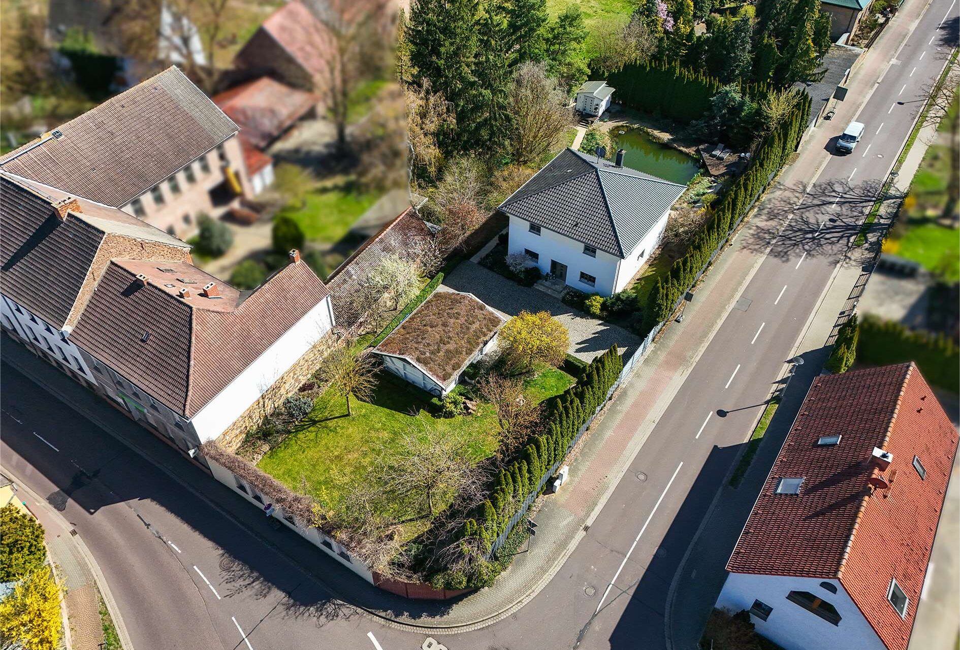 Luftaufnahme eines Wohngebiets mit Einfamilienhäusern, Gärten und einer ruhigen Straße.