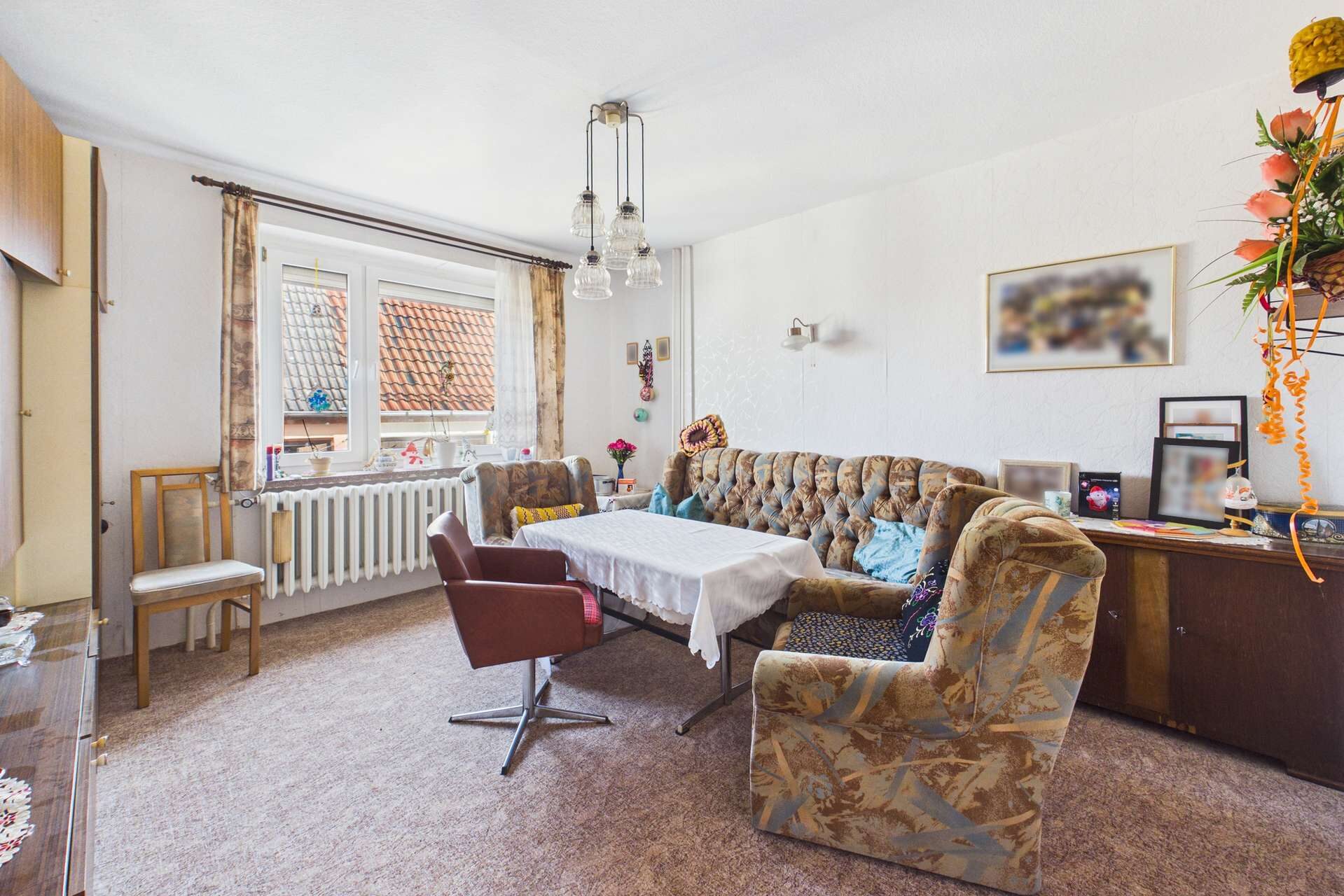 Gemütliches Wohnzimmer mit einem Sofa, einem Tisch und Fenstern, die Tageslicht hereinlassen. Vintage-Dekor und Möbel.
