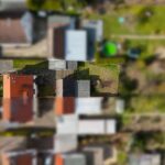 Vogelperspektive auf ein Wohngebiet mit Gärten und Wohnhäusern, im Fokus ein Haus mit roten Ziegeln.