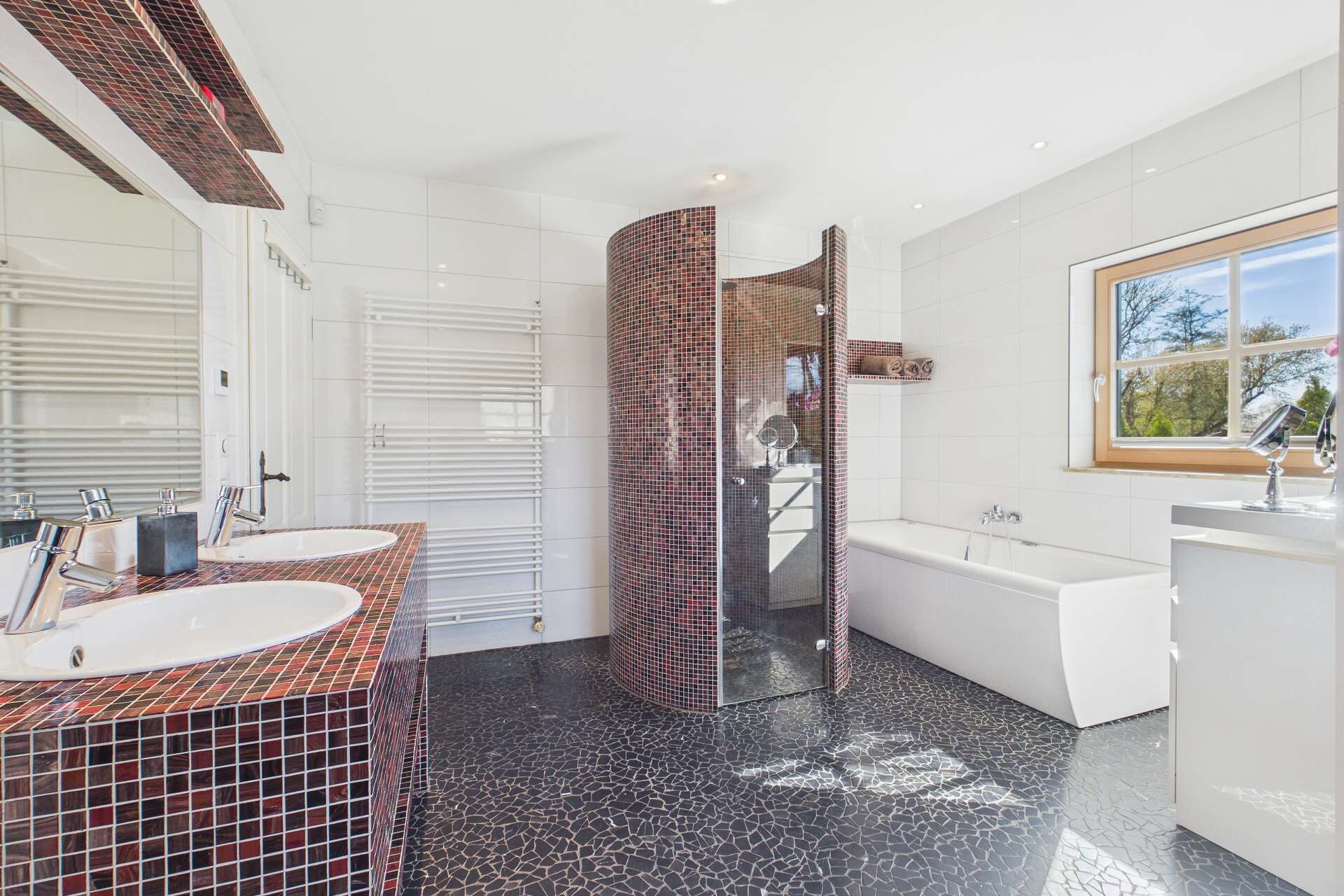 Modernes Badezimmer mit Dusche, Badewanne, Doppelwaschtisch und eleganten Fliesen im schwarz-roten Design.