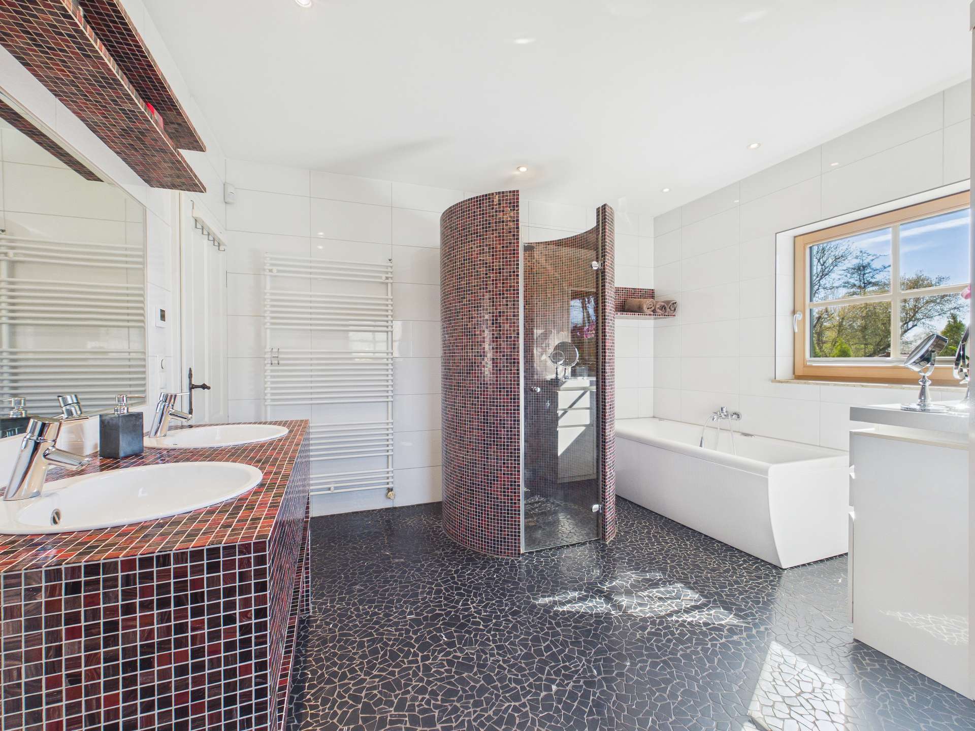Modernes Badezimmer mit Dusche, Badewanne, Doppelwaschtisch und eleganten Fliesen im schwarz-roten Design.