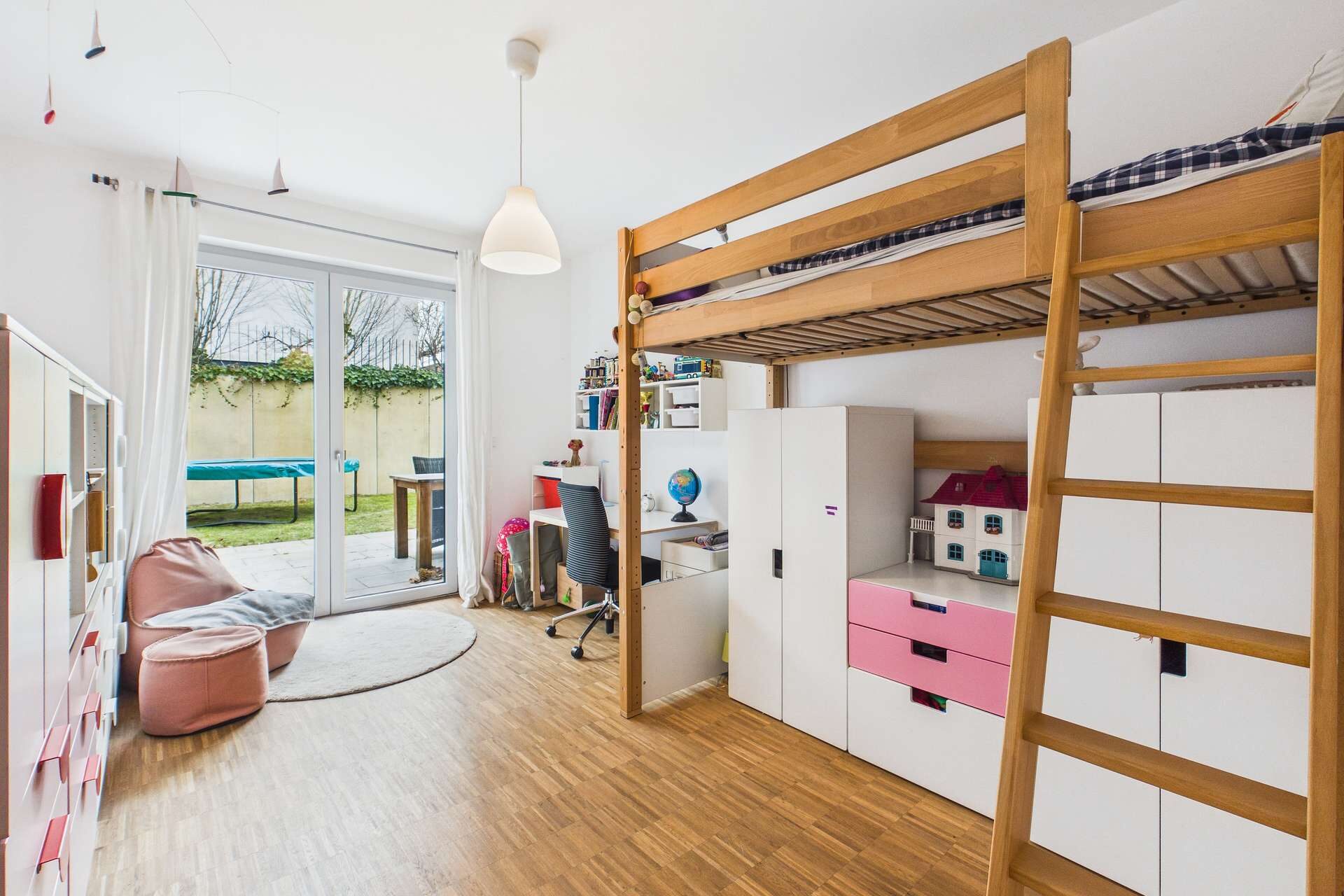Kinderzimmer mit Hochbett, Schreibtisch, Stauraum und Zugang zu einem Garten durch große Fenster.