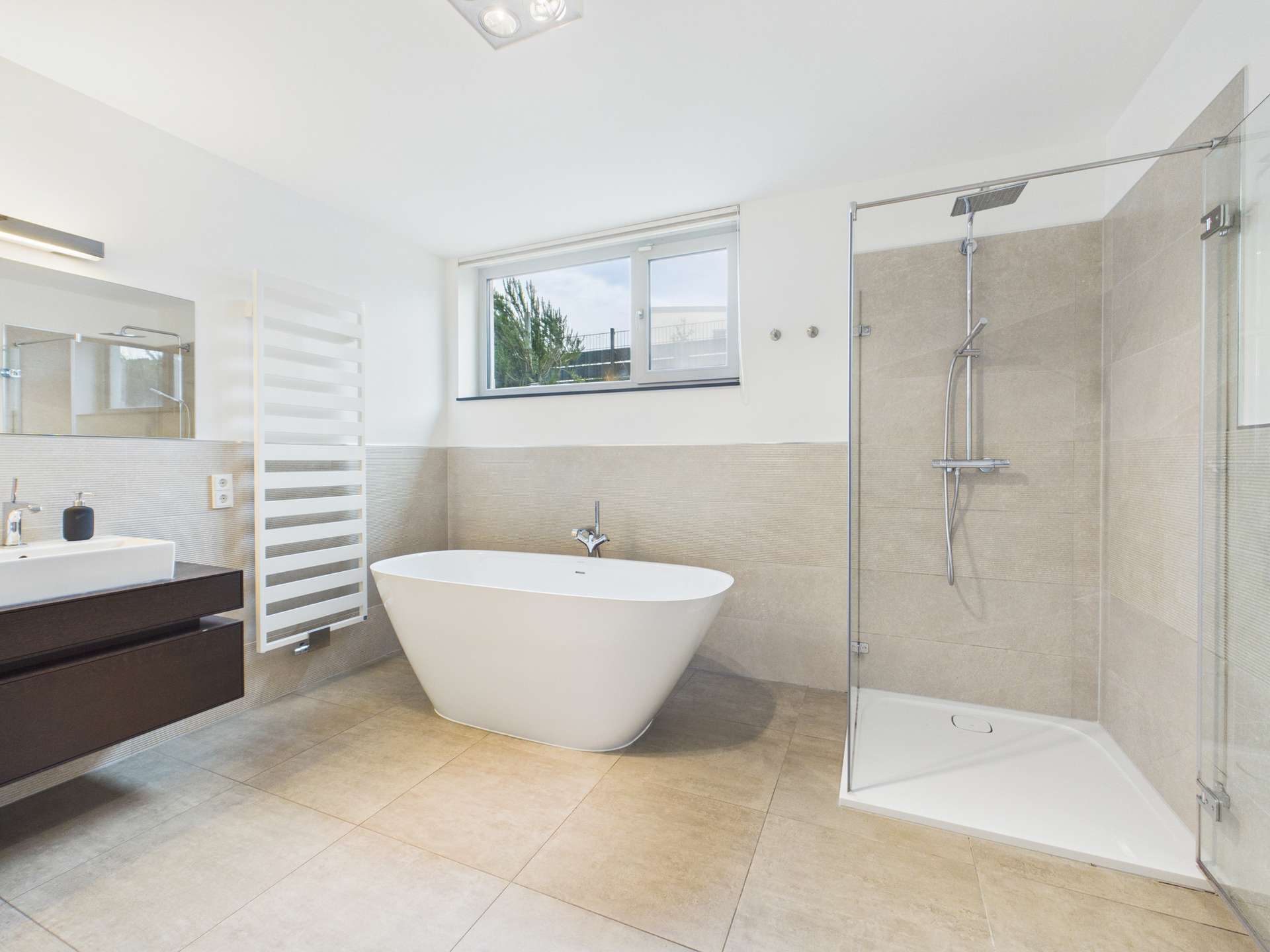 Modernes Badezimmer mit freistehender Badewanne, Dusche, großem Fenster und eleganten Fliesen.