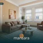 Heller Wohnraum mit beigem Sofa, Sessel, Tisch und Pflanzen, große Fenster und dezente Wandgestaltung.
