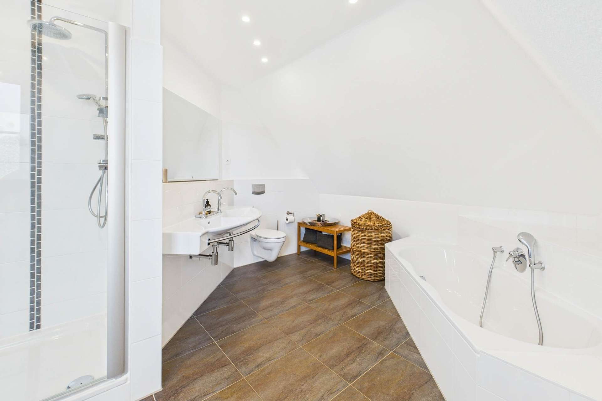 Modernes Badezimmer mit Dusche, Badewanne, Waschbecken und einem Korb aus geflochtenem Material. Helle, neutrale Farben.