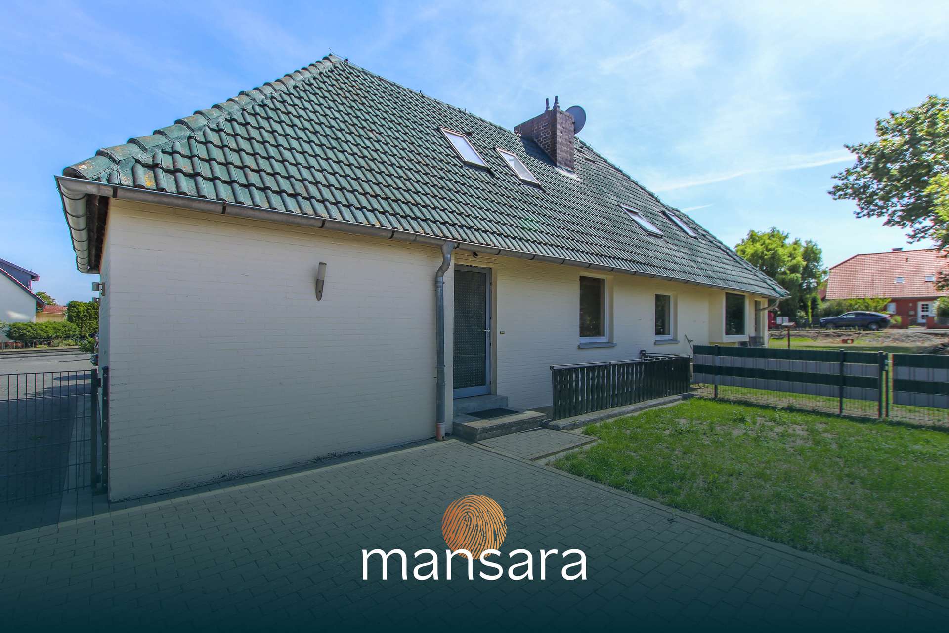 Ein modernes Einfamilienhaus mit grünem Dach und Terrasse, umgeben von Rasen und einem Parkplatz.