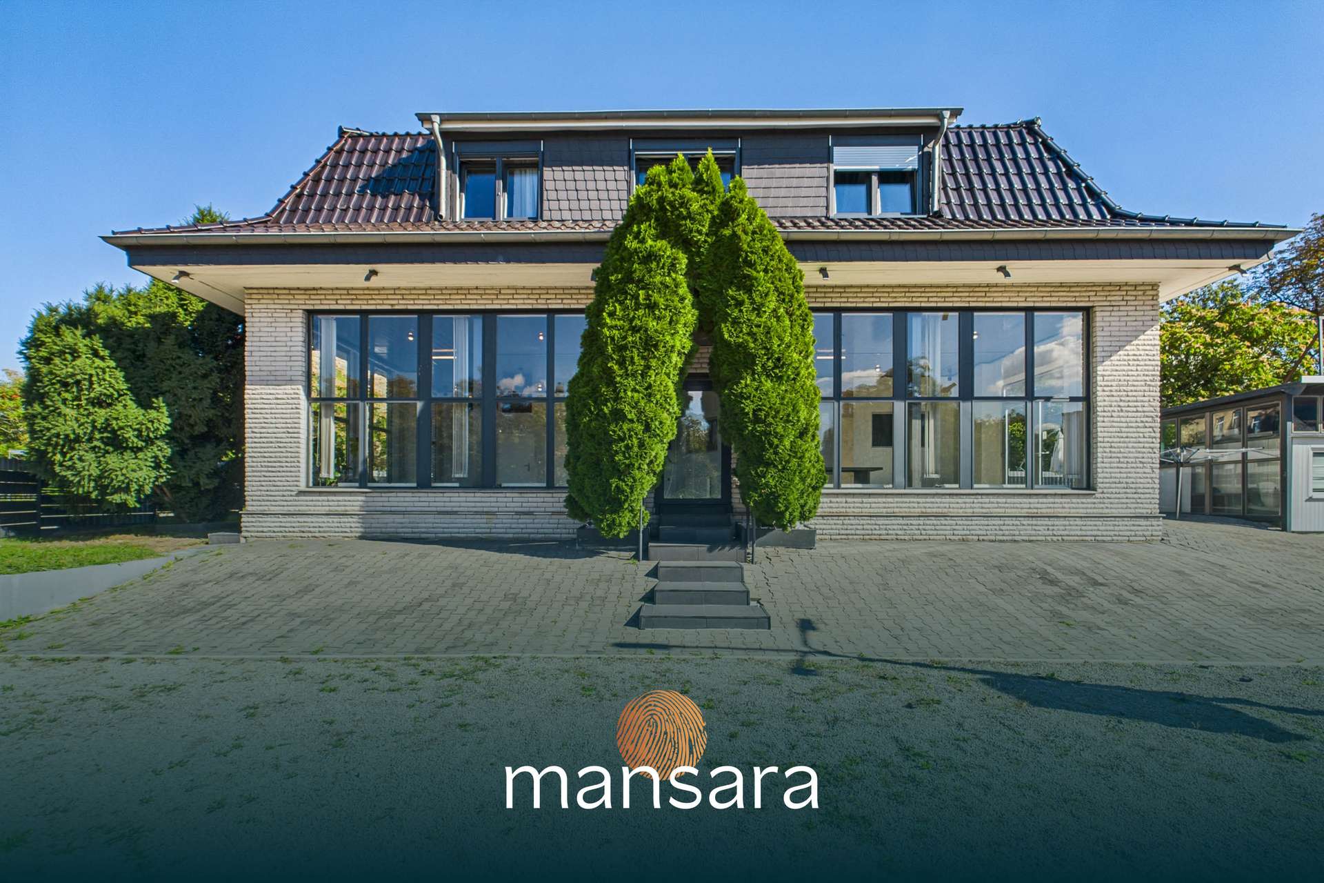 Modernes zweigeschossiges Haus mit großen Fensterfronten und einem auffälligen, grünen Eingang.