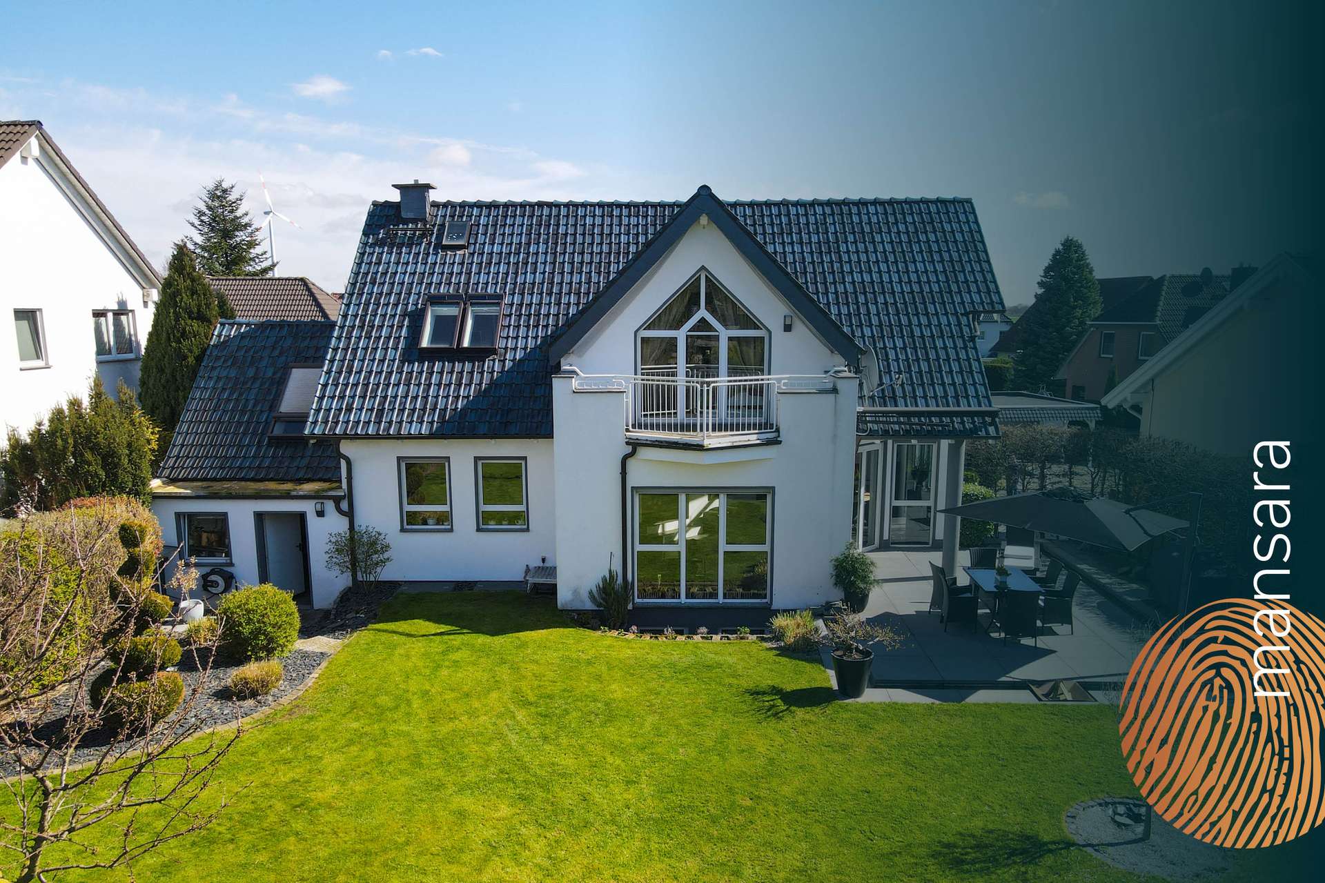 Moderne, zweigeschossige Villa mit Garten und Terrasse, umgeben von grüner Landschaft und klarem Himmel.