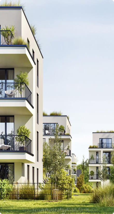 Moderne Wohngebäude mit begrünten Dächern und Balkonen, umgeben von üppigem Grün und Bäumen.